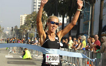 Laura crossing the finish line at the Santa Monica 10k Classic.